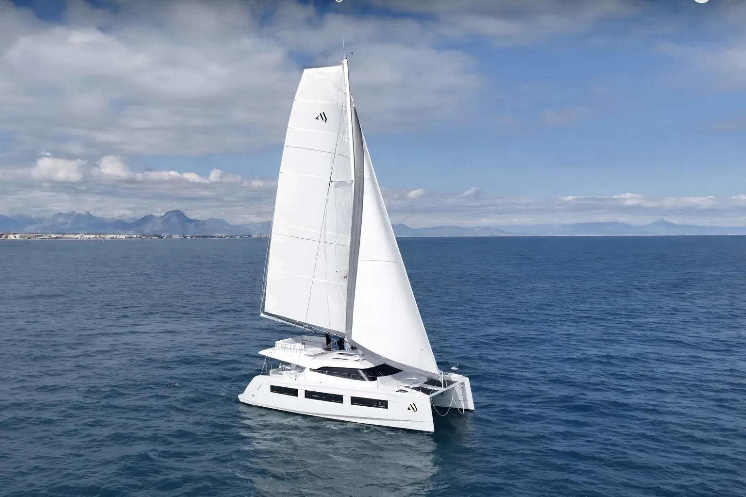 A white Aventura 45 catamaran under full sail on open water